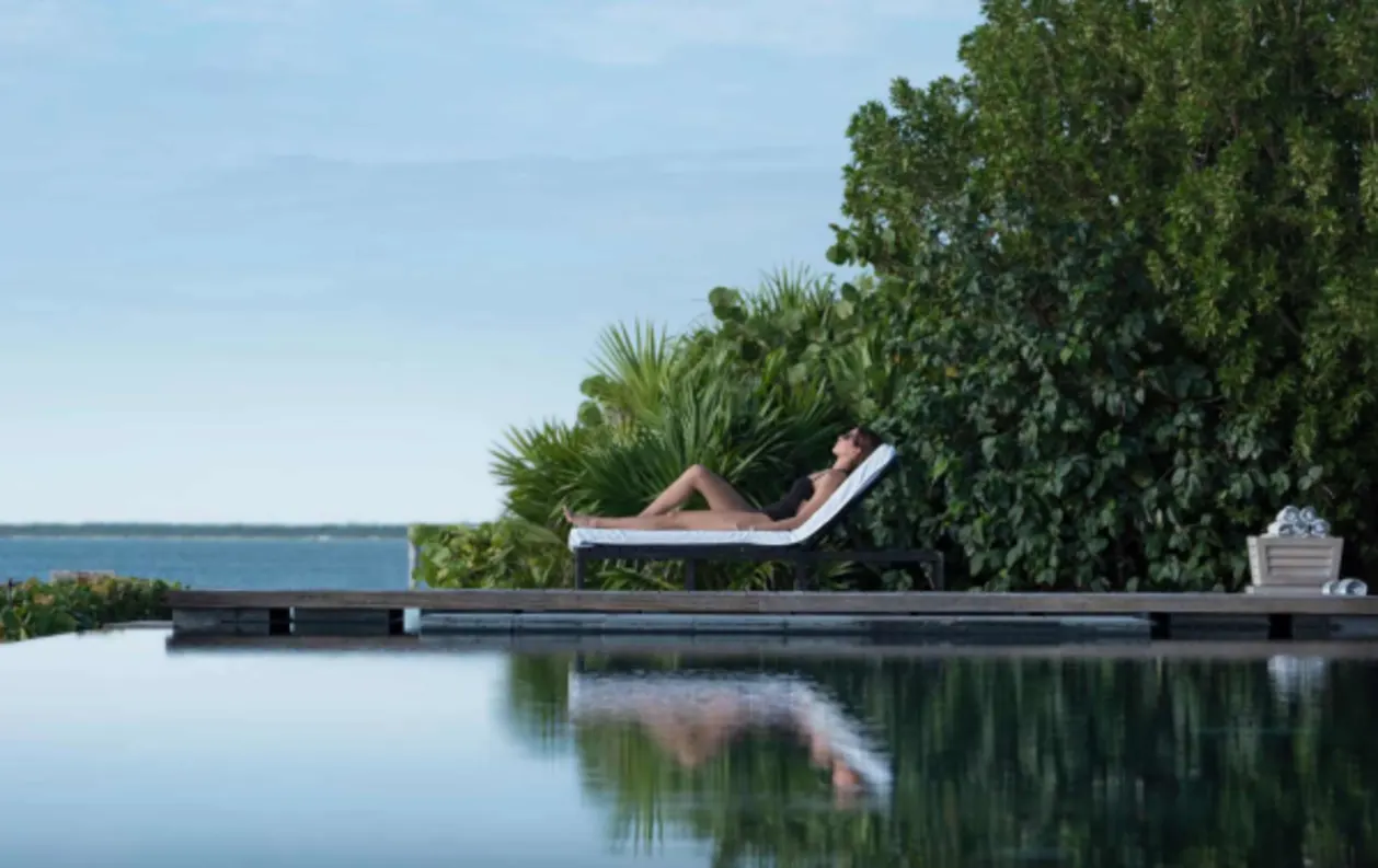 NIZUC Resort & Spa Cancun woman lounging by pool